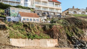 A coastal building with multiple balconies and a sandy beach in the foreground. - Eddystone (Kingsbridge)