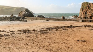 A sandy beach with rocky outcrops and a clear sky. - Eddystone (Kingsbridge)