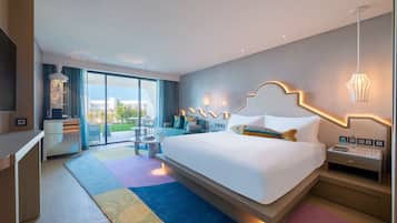 Quarto de hotel moderno com uma cama grande, uma mesa de trabalho e varanda com vista.