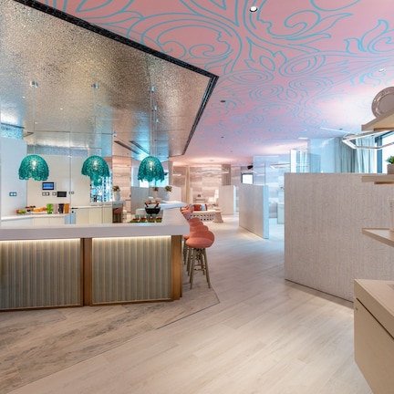Una cocina moderna con una isla central, lámparas colgantes y vista al área del comedor.