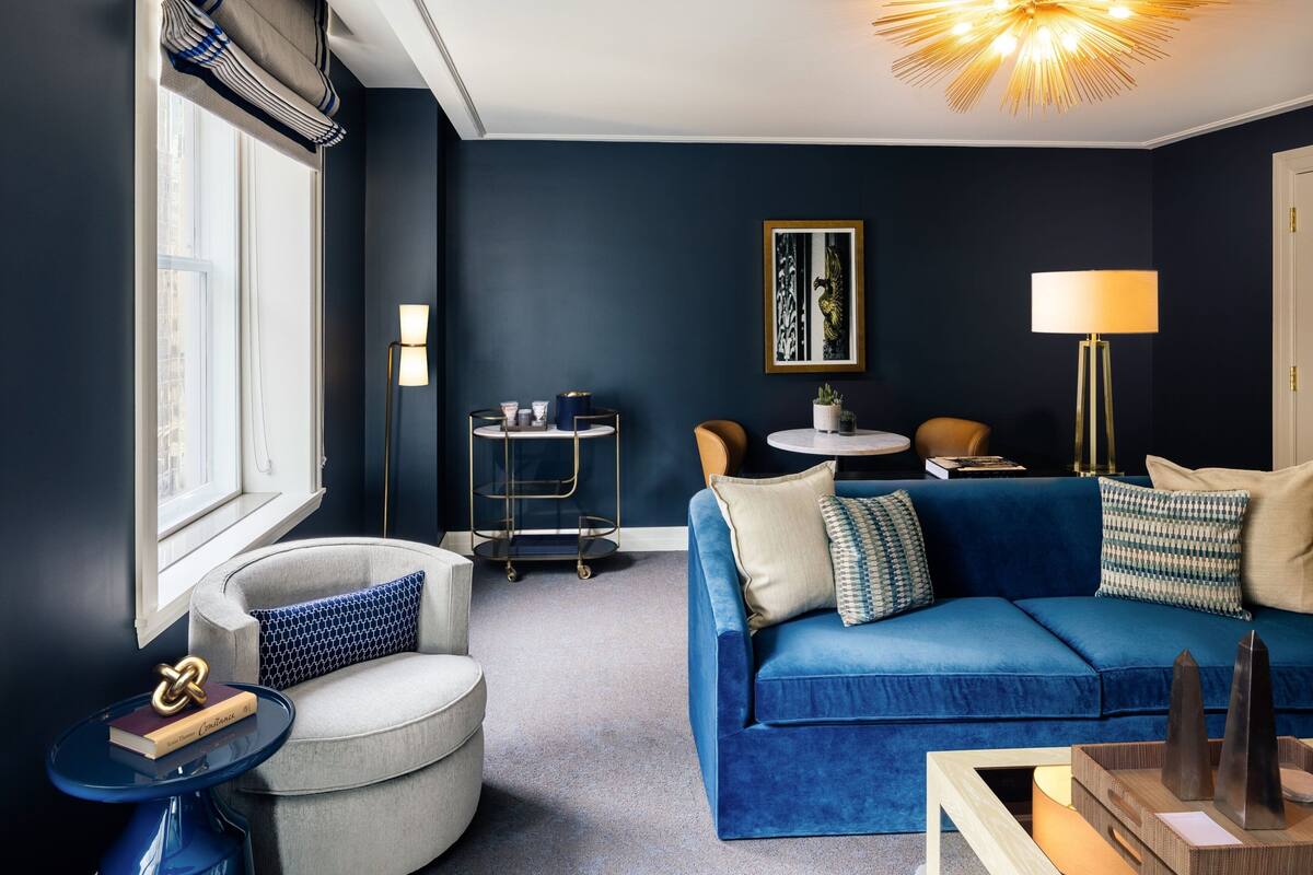 A modern living room with a blue sofa, a round coffee table, and a floor lamp.