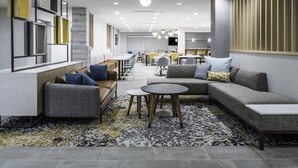 A modern lounge area with sofas, tables, and a patterned rug. - TownePlace Suites by Marriott San Antonio Universal City/Live Oak (Selma)