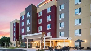 A multi-story hotel with a modern facade, a covered outdoor seating area, and a sign indicating it is a Marriott property. - TownePlace Suites by Marriott San Antonio Universal City/Live Oak (Selma)