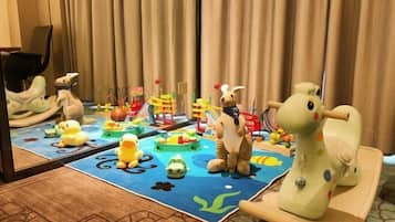 Zona de juegos infantiles con juguetes y un espejo que refleja la habitación.