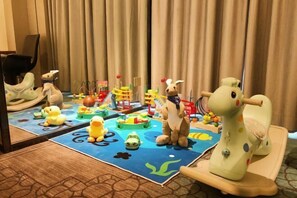 A children's play area with toys and a mirror reflecting the room. - New Glory Holiday Inn (Jurong)