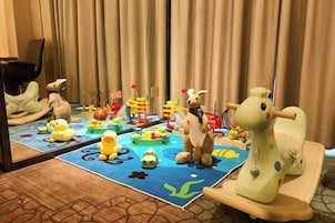 Zona de juegos infantiles con juguetes y un espejo que refleja la habitación.
