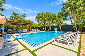 A swimming pool with lounge chairs and a covered seating area. - Deluxe 5BR/3BA Villa in Hollywood Lakes near Beach (Hollywood)