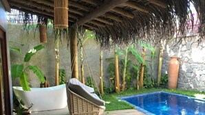 A wooden deck with a pool, a hanging chair, and a table with chairs. - Villa Pantai Boutique Hotel Maragogi (Maragogi)