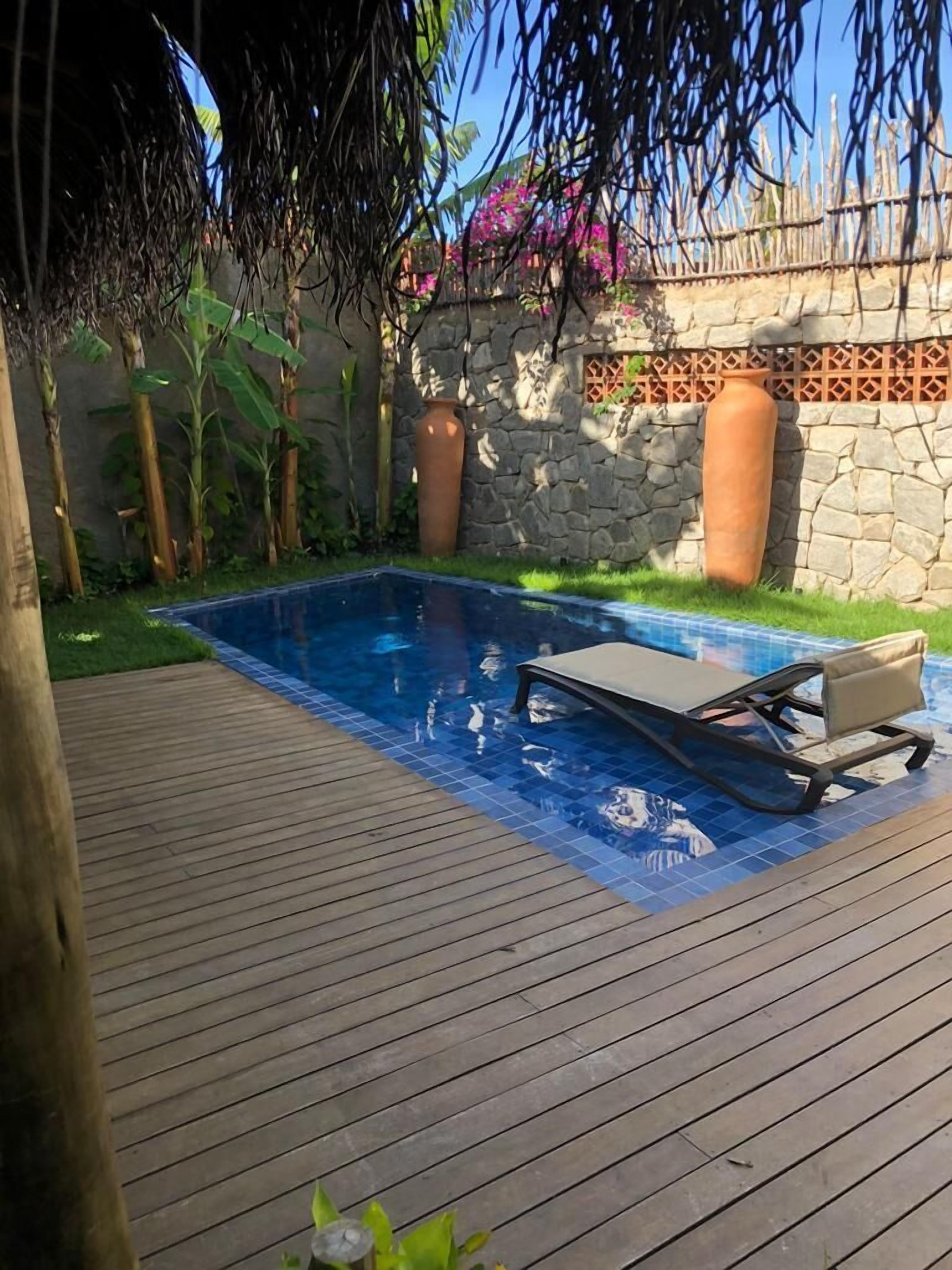 Et rektangulært swimmingpool med en træterrasse hele vejen rundt.
