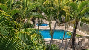 A pool surrounded by palm trees and a white fence. - Maui Banyan ground floor 2 full baths,steps to Kamaole 2,great walking location. (Kihei)