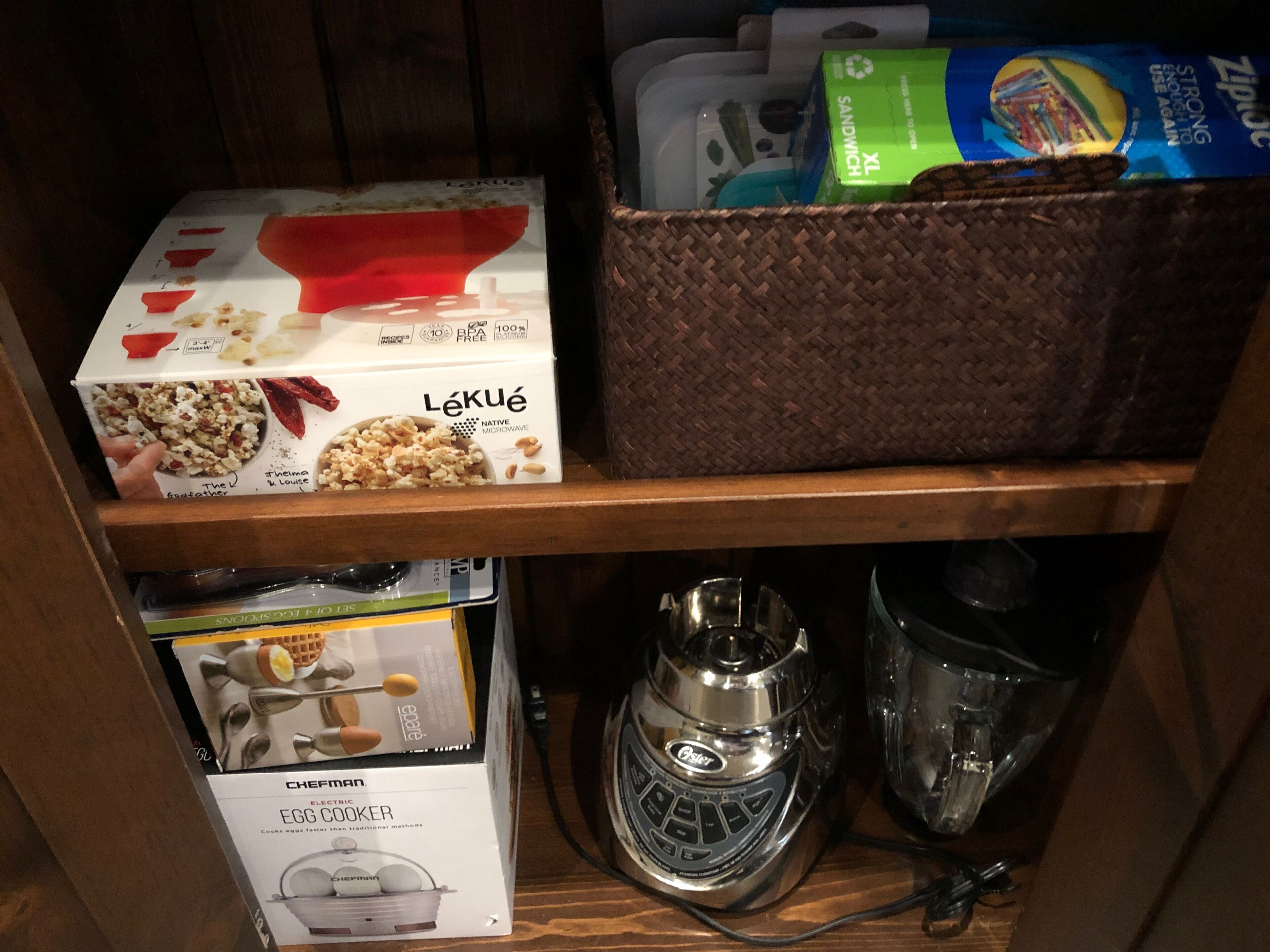 Une étagère avec une boîte de pop-corn, un four à micro-ondes et un panier contenant divers objets.
