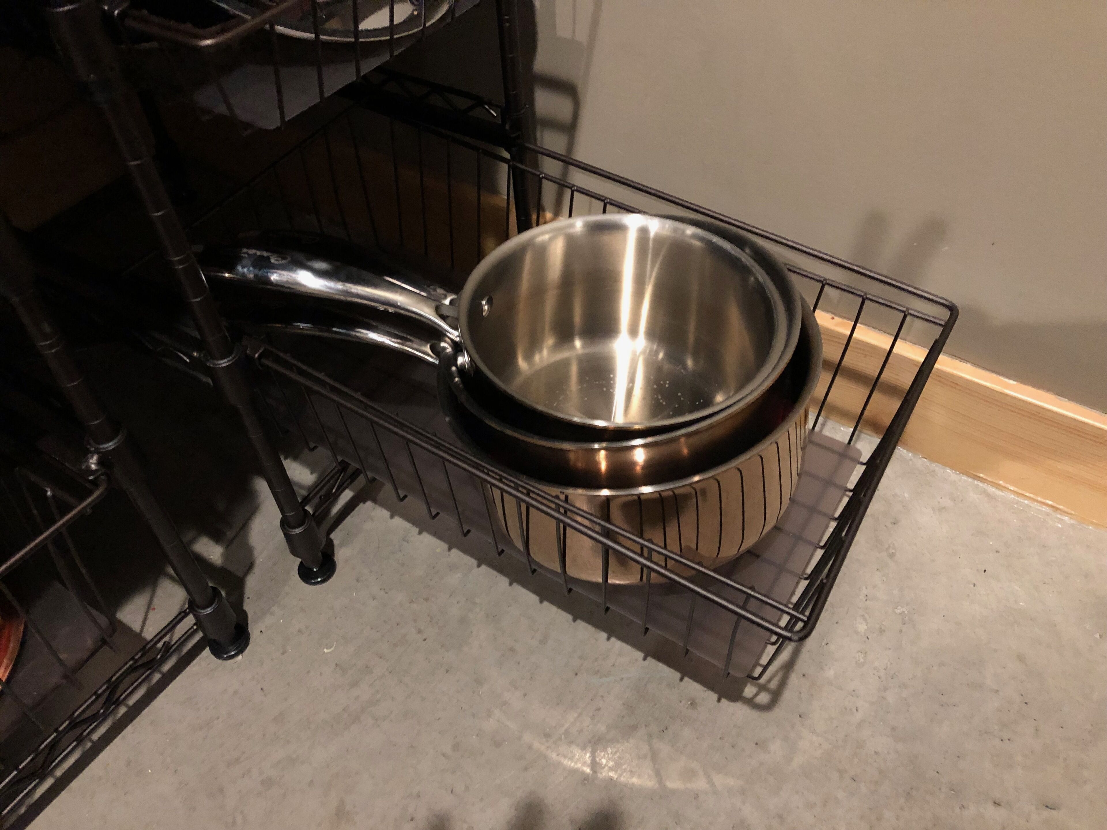 Un coin cuisine avec une casserole en acier inoxydable posée sur une grille métallique.