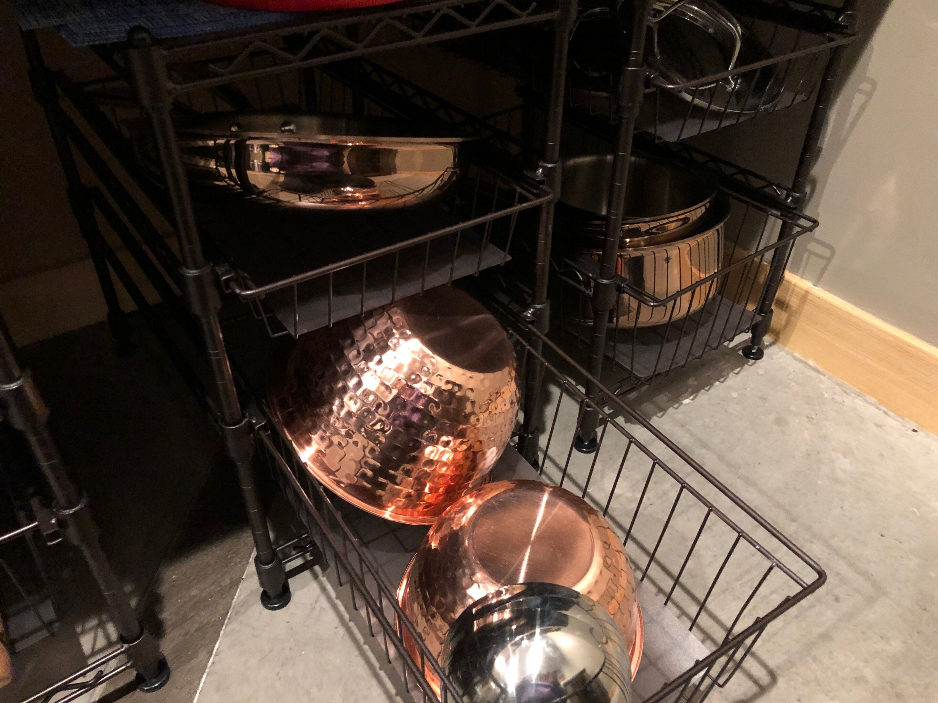 A kitchen with metal shelves holding various cookware.