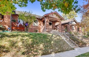 A two-story brick house with a front porch, a staircase leading to the entrance, and a well-maintained lawn. - 3 bedroom vacation home near Denver Botanic Gardens (Denver)