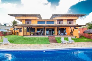 A two-story house with a swimming pool, outdoor seating, and a well-maintained lawn. - Casa do Mar praia de Cotovelo Carpediem (Parnamirim)