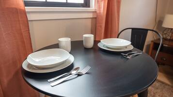 Une table à manger avec des assiettes, des tasses et des couverts.