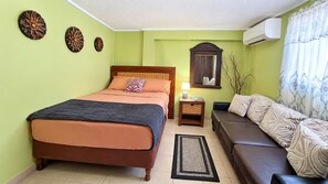 Une chambre à coucher comprenant un lit, une table de chevet, un canapé et des éléments décoratifs muraux.