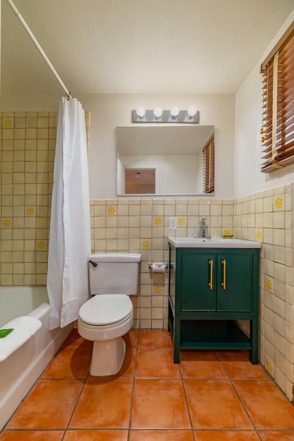 Une petite salle de bain avec des toilettes, un lavabo et un meuble vert.