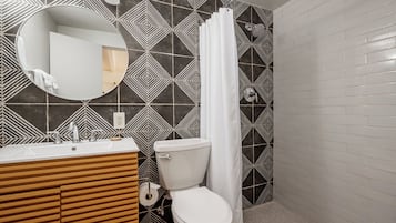 A bathroom with a modern design, featuring a sink, toilet, and shower area.