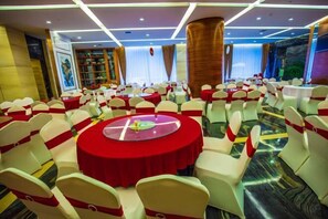 A banquet hall with round tables covered in red tablecloths, white chairs with red sashes, and a polished marble floor. - Jiang Zhou Hotel (Hengyang)