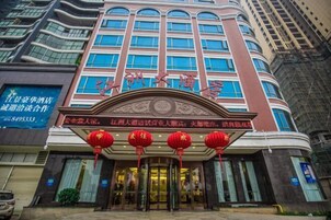 Um hotel com entrada imponente, grandes janelas e tradicionais lanternas vermelhas.