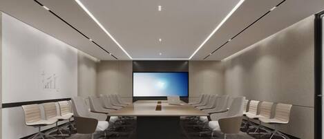 Un salón de conferencias con una gran mesa, sillas, un televisor de pantalla plana y piso alfombrado.