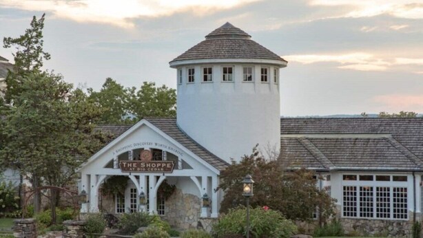 A white building with a tower and a sign that reads "The Shoppe at Big Cedar."