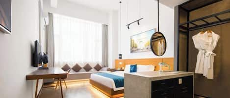 Habitación de hotel con cama, escritorio y una pequeña kitchenette.