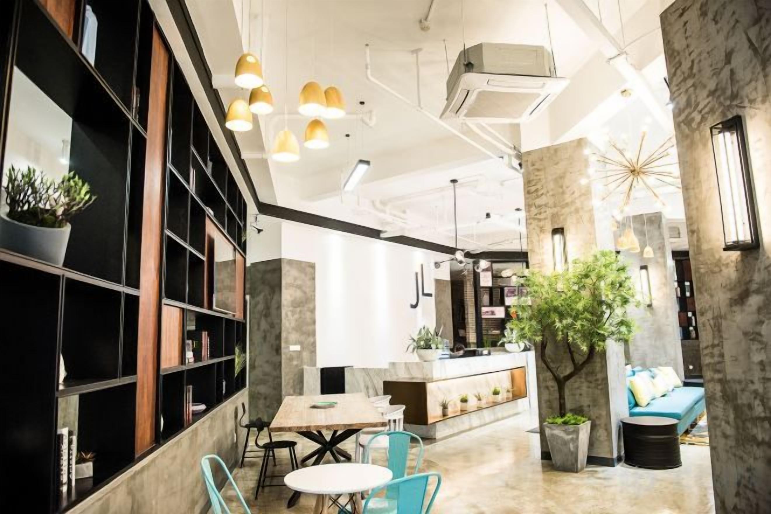 A modern interior with a dining area, bar, and seating with plants.