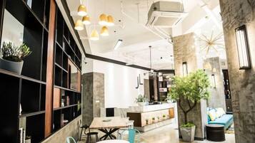 A modern interior with a dining area, bar, and seating with plants.