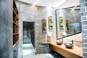 A modern bathroom with a concrete wall, a wooden vanity, and a large mirror. - Jinglan LOFT Boutique Hotel (Baishamen Hainan University) (Haikou)
