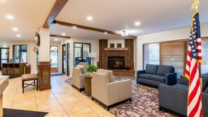 Cozy up by the fireplace in this inviting living area, complete with comfortable seating and a flag.