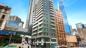 Um edifício alto com vários andares, janelas amplas e design arquitetônico moderno.
