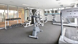 Uma academia moderna com equipamentos de cardio, aparelhos de musculação e halteres.