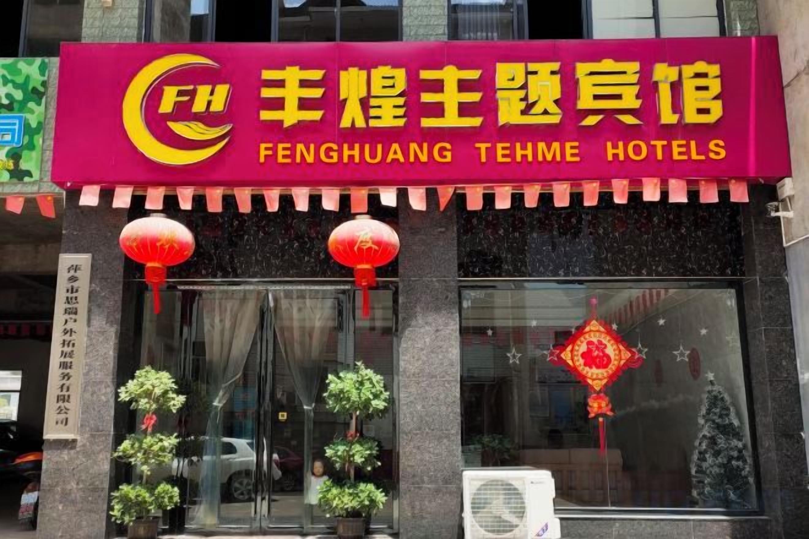 A hotel entrance with a red awning displaying the name 'Fenghuang Tehme Hotels'.