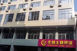 A hotel building with multiple floors and large windows. - Feng Huang Business Hotel (Luxi)