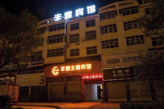 A building with multiple floors, a prominent sign at the top, and several ground-level commercial establishments.