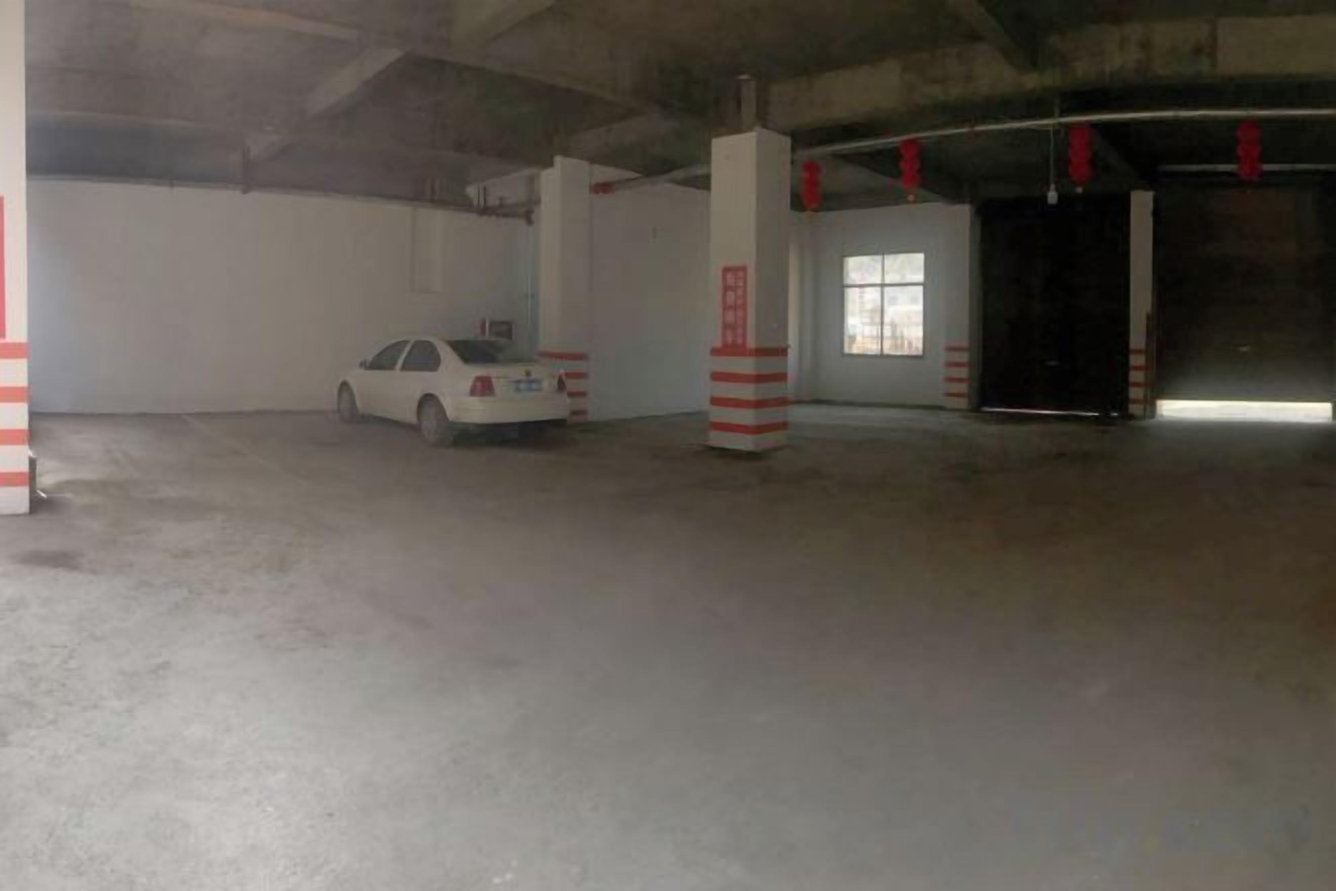 A parking garage with a white car parked near a pillar, a window, and a door.