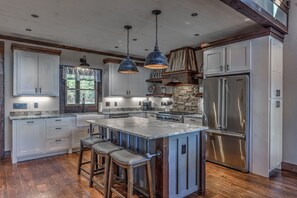 A spacious kitchen with a large island, stainless steel appliances, and wooden accents. - BRAND NEW! Sunrock Mountain Dream ~ LUXURY Cabin (Blue Ridge)
