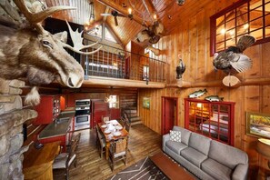 Un intérieur rustique comprenant un coin repas, une cuisine et un espace en mezzanine.