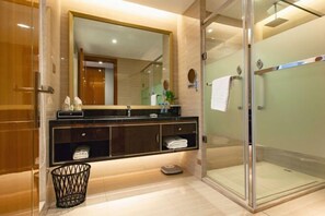 A modern bathroom with a glass shower enclosure, a large mirror, and a vanity with a towel rack. - Hui Chang Hotel (Huichang)