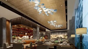 A modern restaurant with a bar area, wooden ceiling, and a large wall mural. - Hui Chang Hotel (Huichang)