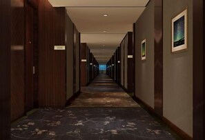 A long, narrow hotel corridor with wooden walls and a carpeted floor. - Hui Chang Hotel (Huichang)