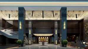 A modern lobby with a central reception desk, large pillars, and a glass ceiling. - Hui Chang Hotel (Huichang)