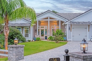 A two-story house with a brick facade, a front porch, and a garage. - Seabreeze 30A: Luxe 5BR w/ Pool & Beach Access (Rosemary Beach)