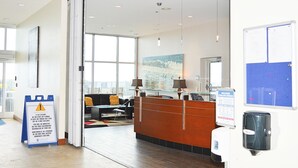 A modern hotel lobby with a reception desk, seating area, and large windows. - Sterling Breeze 2Bd/3Ba w/Bunk Room / Near Pier Park /Sleeps 8 (Panama City Beach)