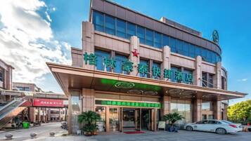 A hotel with a modern facade, a prominent entrance, and a visible staircase leading to the entrance.