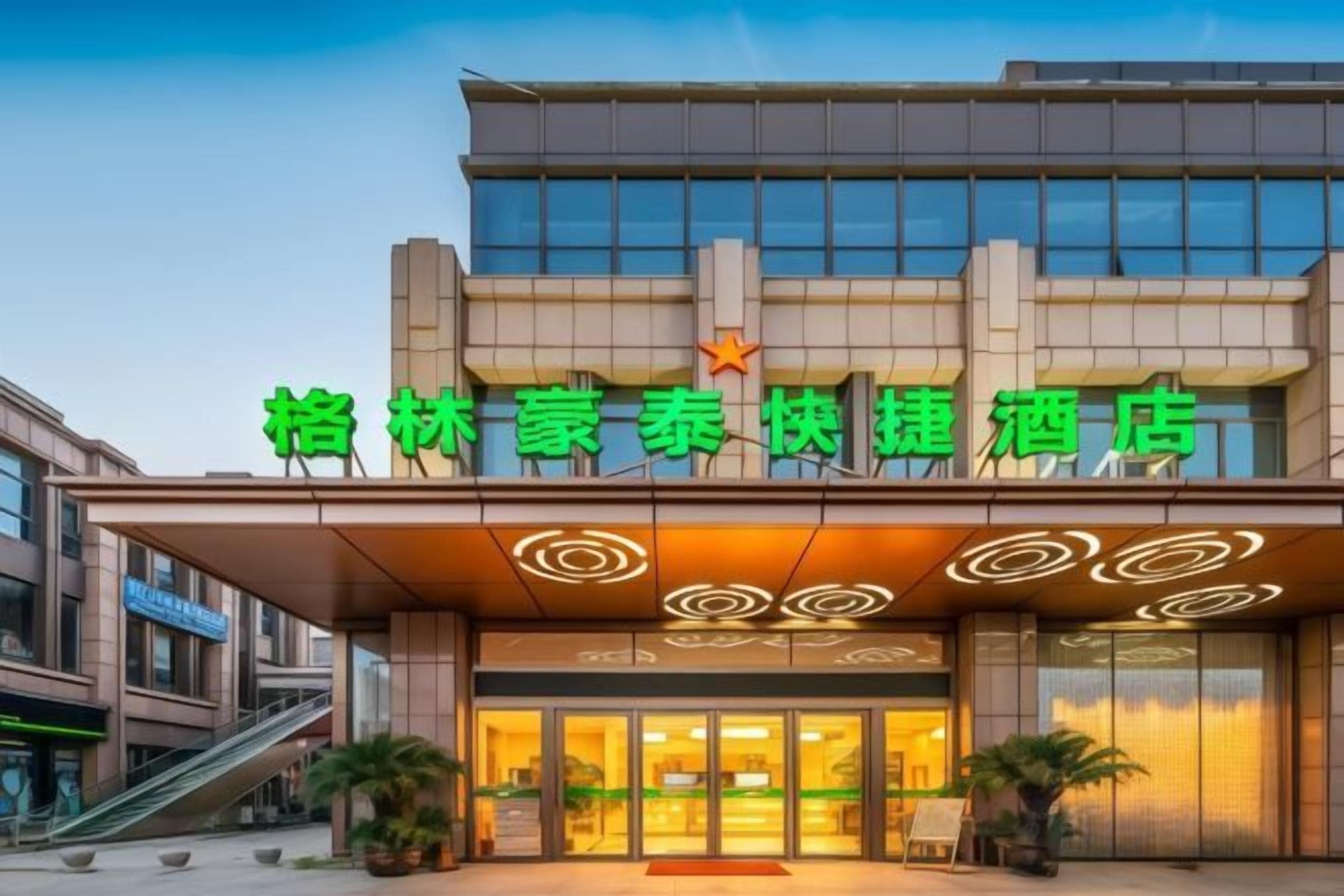 A hotel with a modern facade, a prominent entrance, and a star symbol above the name.