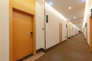 A hotel hallway with doors, carpeted floors, and ceiling lights. - GreenTree Hotel (Nantong University International Exhibition Center) (Nantong)