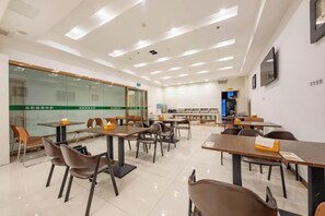 A modern conference room with tables and chairs, a glass partition, and a television screen. - GreenTree Hotel (Nantong University International Exhibition Center) (Nantong)